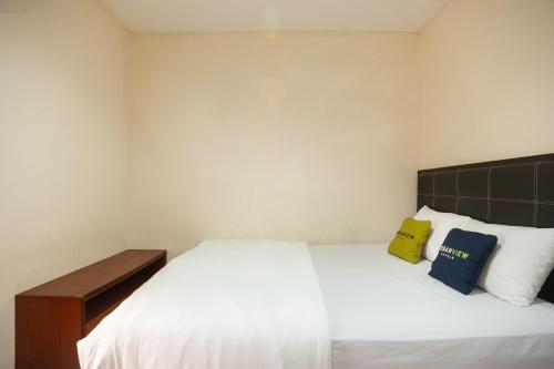 ボゴールにあるUrbanview Hotel Syariah Villa SM Cisarua Puncak by RedDoorzの大きな白いベッドと枕が2つある寝室