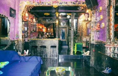 een woonkamer met een blauwe bank en een bar bij VINTOUCH CHIC in Seminyak