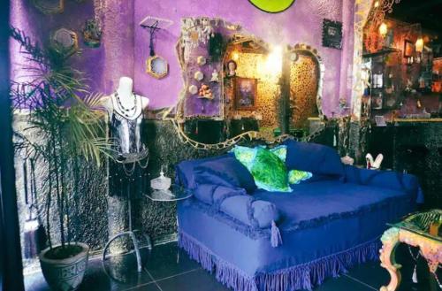 een paarse slaapkamer met een blauwe bank in een kamer bij VINTOUCH CHIC in Seminyak