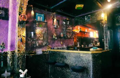 een bar met zwarte krukken in een kamer bij VINTOUCH CHIC in Seminyak