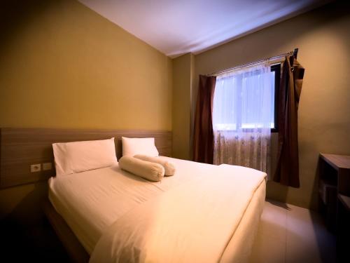 sypialnia z białym łóżkiem i oknem w obiekcie Mess MT Haryono w mieście Sampit
