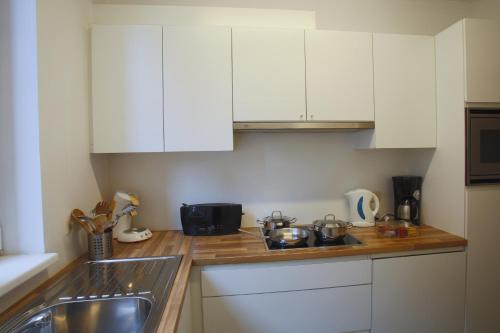 a kitchen counter with white cabinets and a sink at Apartments Ypres in Ypres