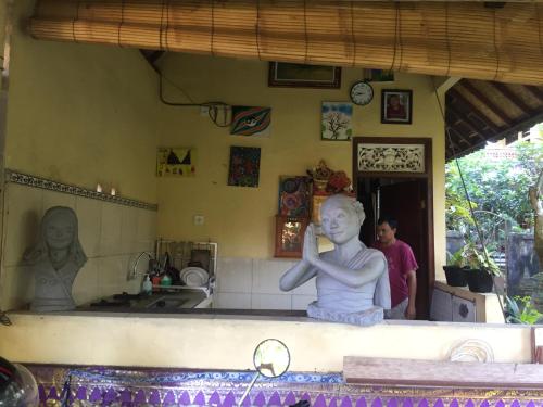 a statue of a woman sitting on a counter in a kitchen at Kenari House in Ubud