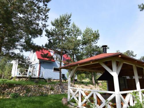 a gazebo in a yard next to a house at Holiday Home near Lake Mausz with Sauna in Kłodno