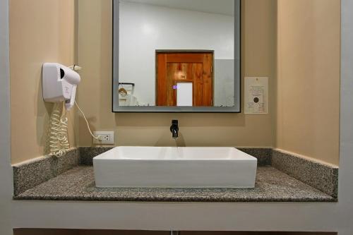 a white sink in a bathroom with a mirror at Bathala Resort in Panglao
