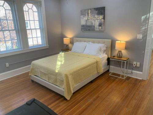 ein Schlafzimmer mit einem Bett und zwei Tischen mit Lampen in der Unterkunft Cozy 2BD/2BA Apartment in Baltimore