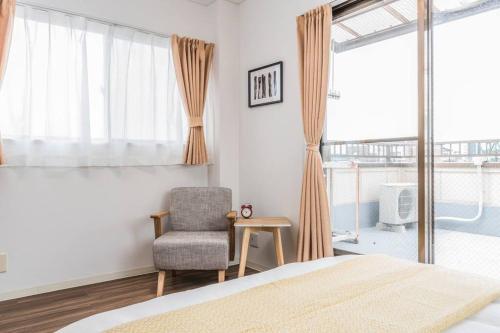 a bedroom with a bed and a chair and a window at Osaka Viewing House丨4min-st aion丨Near Namba, Umeda liubj4 in Osaka