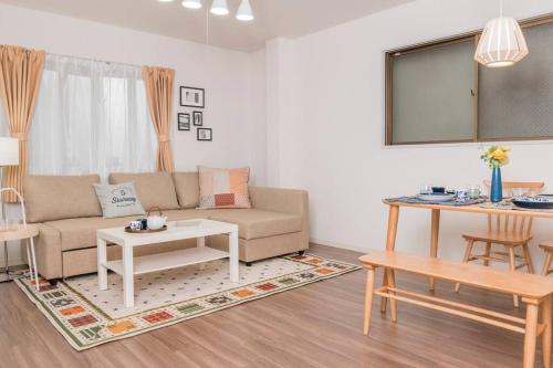 a living room with a couch and a table at Osaka Viewing House丨4min-st aion丨Near Namba, Umeda liubj4 in Osaka