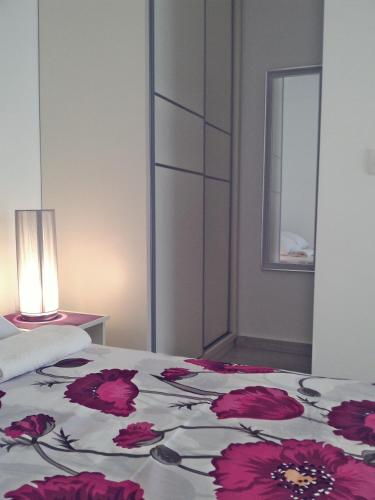 a bedroom with a bed with red flowers on it at Kotor Kelly Apartments in Kotor