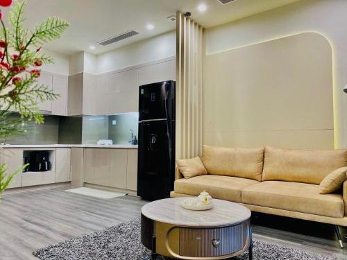 een woonkamer met een bank en een tafel bij Shin's Conner- 1 bedroom apartment 50m2 at Vinhomes Ocean Park in Hanoi