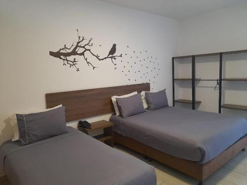 a bedroom with two beds and a bird on a branch at Hotel Entre Lomas in Santa Rosa de Cabal