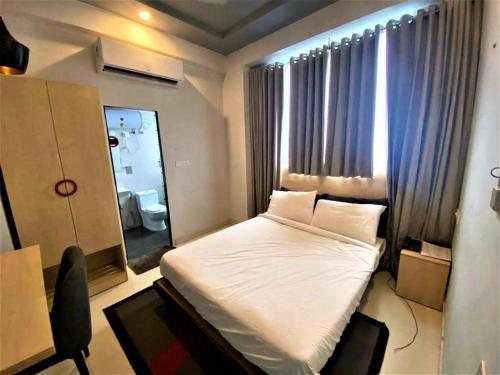 ein kleines Schlafzimmer mit einem Bett und einem Spiegel in der Unterkunft Jaipur Grand By StayApart in Jaipur