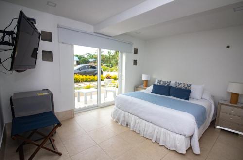 a bedroom with a bed and a tv in it at CAMATAJUA BARU HOUSE in Playa Blanca