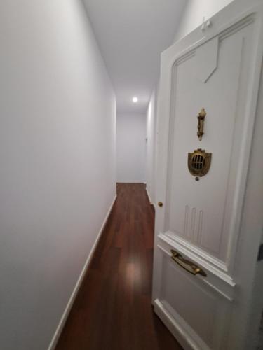 pasillo con puerta blanca y suelo de madera en Loft Turístico Bouzas, en Vigo