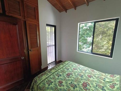 1 dormitorio con cama y ventana en Casa Campestre Poblado para 8 en Medellín