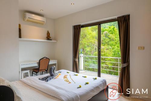 a bedroom with a bed and a large window at Chaweng Hill Apartment 2Br & Private Pool in Koh Samui 
