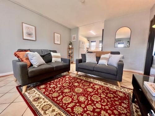 ein Wohnzimmer mit 2 Sofas und einem Teppich in der Unterkunft Renovated 2 Bedroom - Managers Apartment in South Hedland