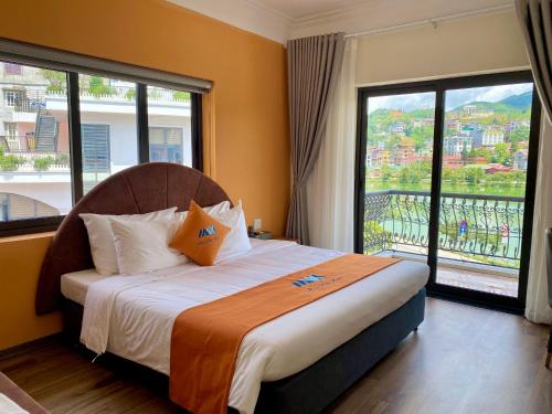 een slaapkamer met een bed en een groot raam bij Sapa Legacy Hotel in Sa Pa