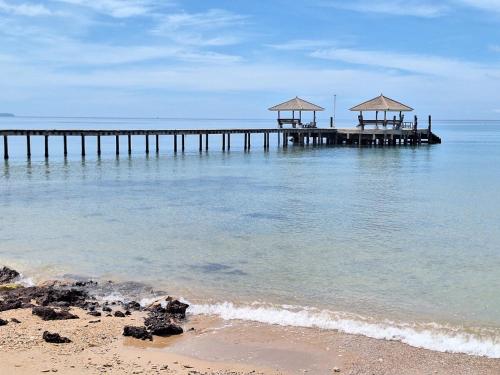 a pier in the water with a beach and the ocean at Miss You Beach Resort Koh Mak in Ko Mak