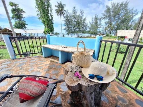 a bench with a hat and sunglasses sitting on a tree stump at Miss You Beach Resort Koh Mak in Ko Mak