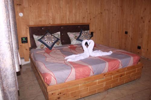 Un dormitorio con una cama con un cisne blanco. en Hotel Mannat Sach Pass en Tisa