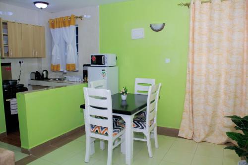 eine Küche mit einem Tisch und Stühlen in der Unterkunft Epic Village in Nairobi