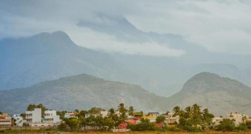 Revathy Tourist Home في Kallar-Bridge: اطلالة على مدينة فيها جبال في الخلفية