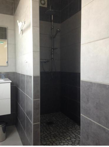La salle de bains est pourvue d'une douche avec du carrelage noir et blanc. dans l'établissement Maison en plein cœur de la tranche sur mer 500 m plage, à La Tranche-sur-Mer