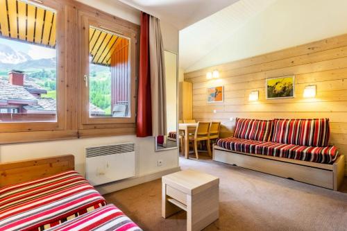 un salon avec un canapé et une fenêtre dans l'établissement Résidence Plagne Lauze - maeva Home - Studio 4 Personnes - Sélection MAE-4324, à Mâcot La Plagne