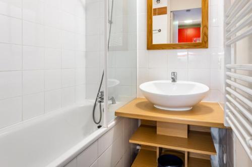 une salle de bain avec un lavabo et une baignoire dans l'établissement Résidence Plagne Lauze - maeva Home - Studio 4 Personnes - Sélection MAE-4324, à Mâcot La Plagne