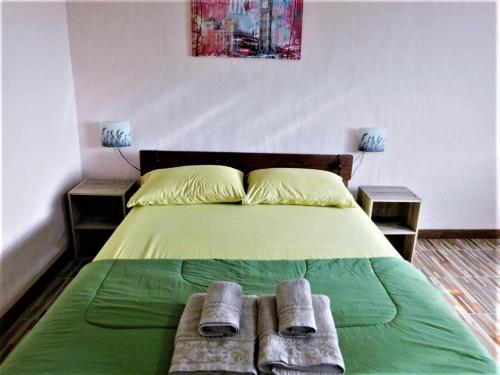 a bedroom with a green bed with two towels on it at Swiss Bonihouse Koh Yao Yai in Ban Phlu Nai