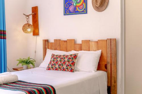 a bed with a wooden headboard in a room at In Wotoch Departamentos con Estacionamiento in Valladolid