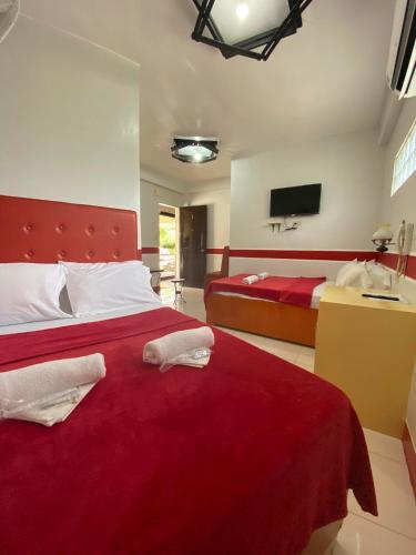 a bedroom with two beds and a red blanket at Casa Marie Hotel in Daet