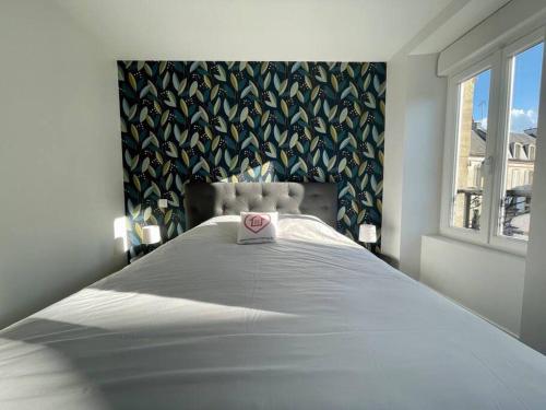 a bedroom with a bed with a heart on it at Logis de la Pomme d'Or x Melrose in Bayeux