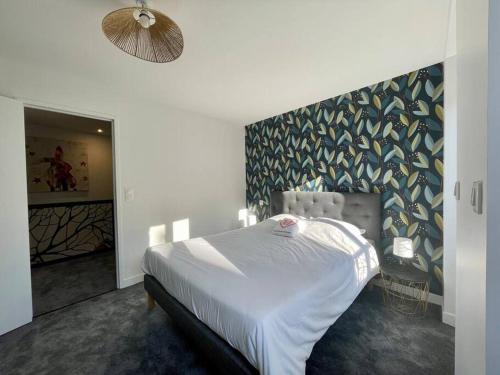 une chambre avec un lit blanc et un mur dans l'établissement Logis de la Pomme d'Or x Melrose, à Bayeux