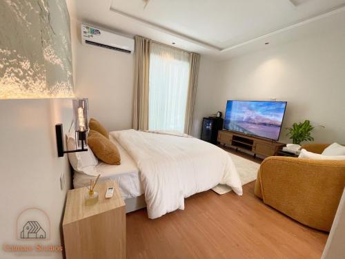 a bedroom with a bed and a flat screen tv at Modern studio with self check-in in Riyadh