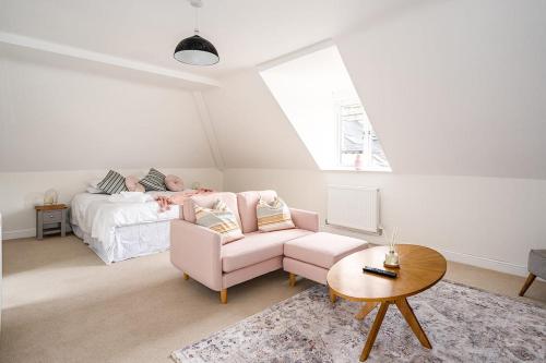 a living room with a pink couch and a bed at Spacious 2 Bedroom House With Stunning Views in Bath