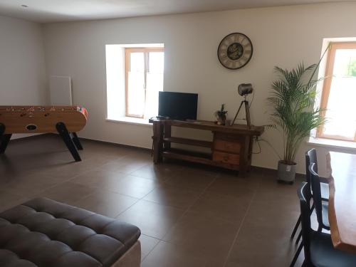 a living room with a couch and a table at gîte proche des cascades du Hérisson 6 personnes in Doucier