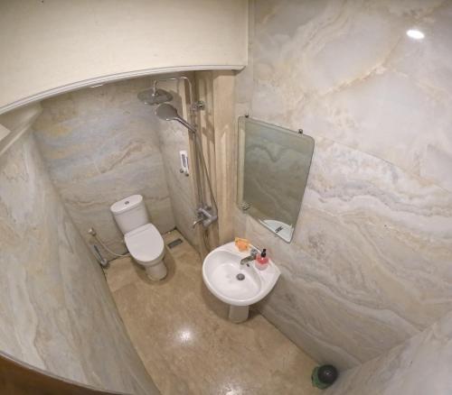 a bathroom with a sink and a toilet and a mirror at Villa Casa Baiti Syariah Malioboro in Jetis
