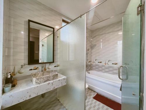 a bathroom with a shower and a sink and a mirror at HueNam Residence in Hue
