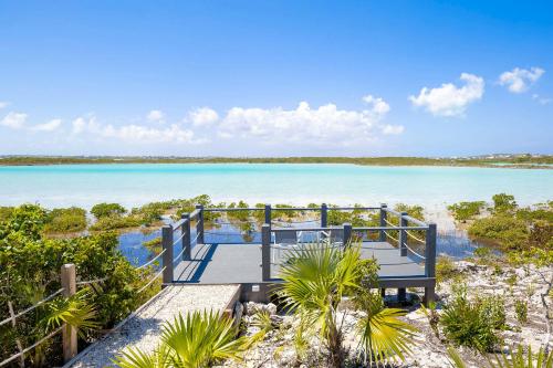 eine Promenade, die zu einem Strand mit dem Meer führt in der Unterkunft NEW Tropical Waterfront Cooper Jack Bay Villas in Five Cays Settlement