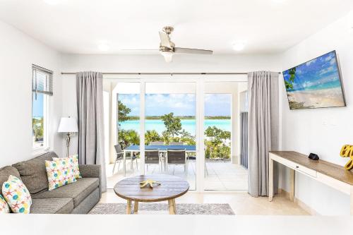 a living room with a couch and a table at NEW Tropical Waterfront Cooper Jack Bay Villas in Five Cays Settlement