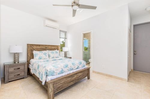 a bedroom with a bed and a nightstand and a window at NEW Tropical Waterfront Cooper Jack Bay Villas in Five Cays Settlement