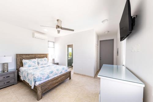 a bedroom with a bed and a flat screen tv at NEW Tropical Waterfront Cooper Jack Bay Villas in Five Cays Settlement