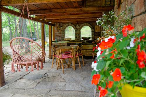 un patio con mesa, sillas y flores en Brvnara Mila Vila en Pranjani