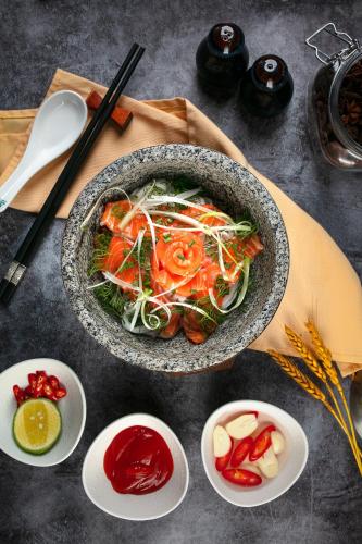 a bowl of food on a table with chopsticks and sauces at Lucien Hanoi Lakeside Hotel & Rooftop in Hanoi