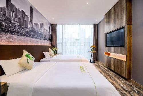 ein Hotelzimmer mit 2 Betten und einem TV in der Unterkunft Heye International Youth Hostel in Chongqing