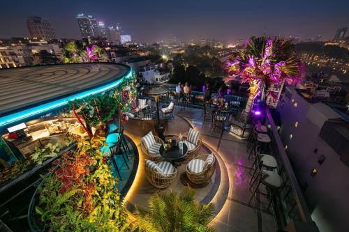 a view of a restaurant at night with palm trees at Lucien Hanoi Lakeside Hotel & Rooftop in Hanoi