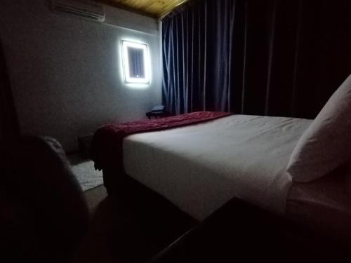 - une chambre avec un lit dans une pièce dotée d'une fenêtre dans l'établissement Budget Room, à Pietermaritzburg