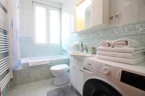 y baño blanco con lavadora. en Retro Apartment, en Sarajevo